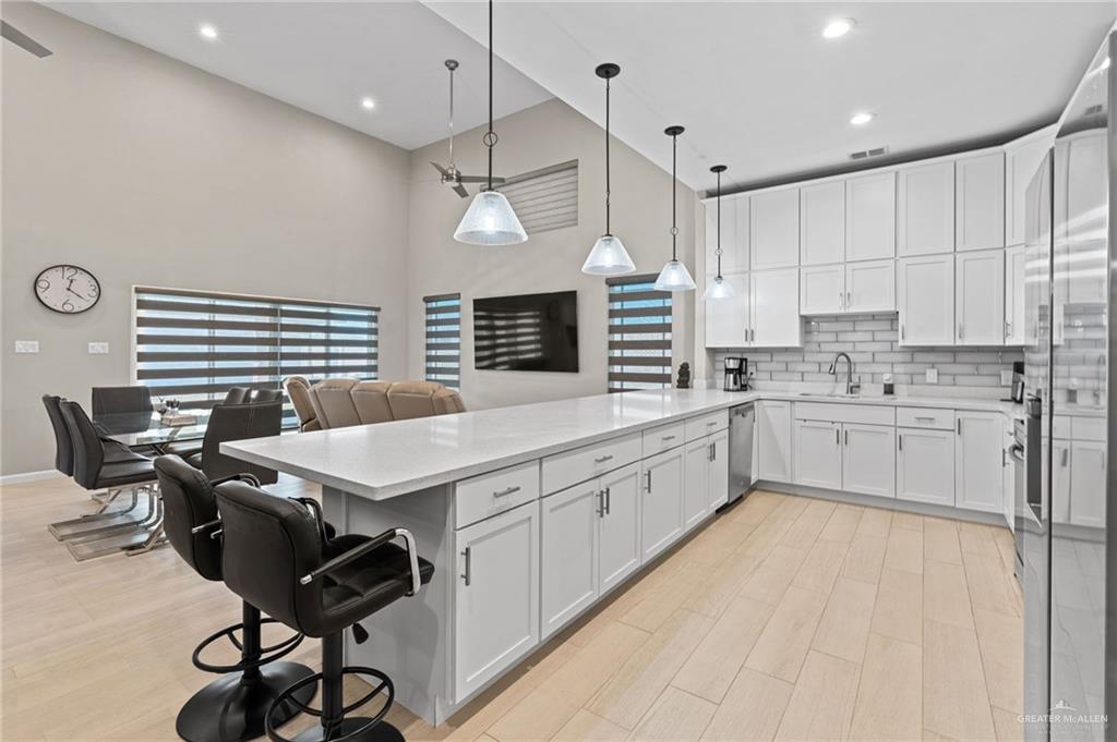 1127 Fairway Lane Harlingen, TX 78552 - Photo 7 of 23 a kitchen with stainless steel appliances kitchen island granite countertop a sink a stove a refrigerator cabinets and a window