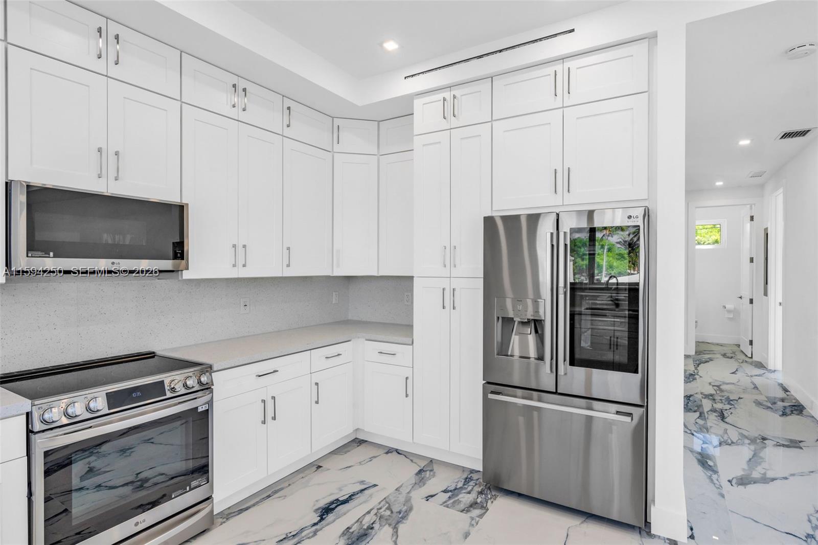 84 Coral Way Key Largo, FL 33037 - Photo 13 of 55 a kitchen with stainless steel appliances white cabinets and a refrigerator