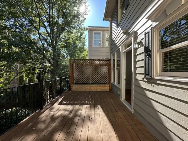 a view of a pathway of a house with wooden floor next to a yard