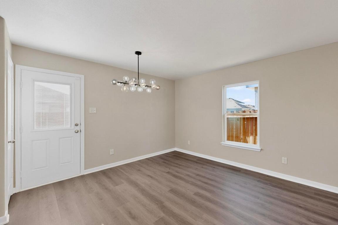 606 Aplite Pass Maxwell, TX 78656 - Photo 14 of 30 Unfurnished dining area with a chandelier and light wood-type flooring