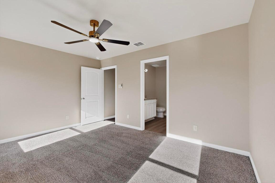 606 Aplite Pass Maxwell, TX 78656 - Photo 17 of 30 Unfurnished bedroom with carpet flooring, a ceiling fan, and connected bathroom