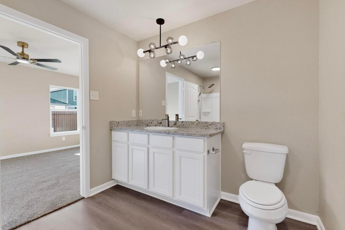 606 Aplite Pass Maxwell, TX 78656 - Photo 18 of 30 Bathroom with vanity, dark wood-style flooring, a shower, and a ceiling fan