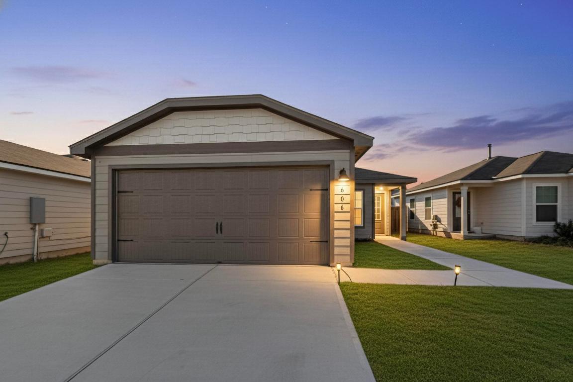 606 Aplite Pass Maxwell, TX 78656 - Photo 2 of 30 View of front of home with a front yard, concrete driveway, and a garage