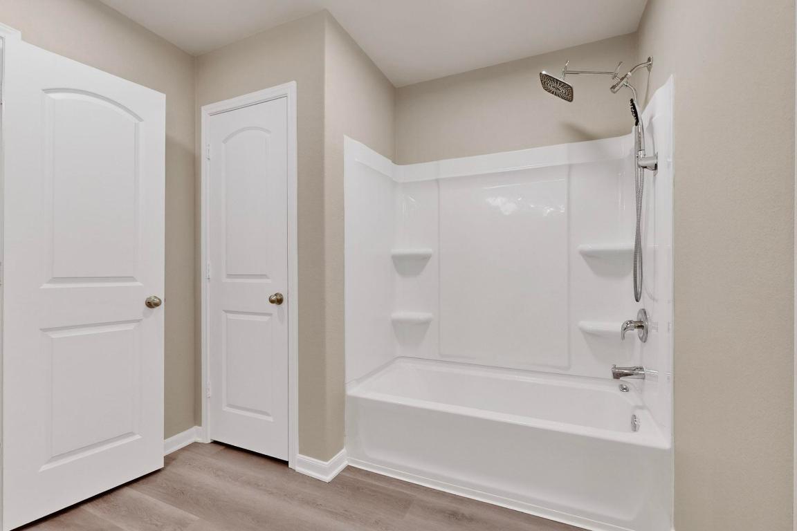 606 Aplite Pass Maxwell, TX 78656 - Photo 26 of 30 Bathroom with tub / shower combination and light wood-type flooring