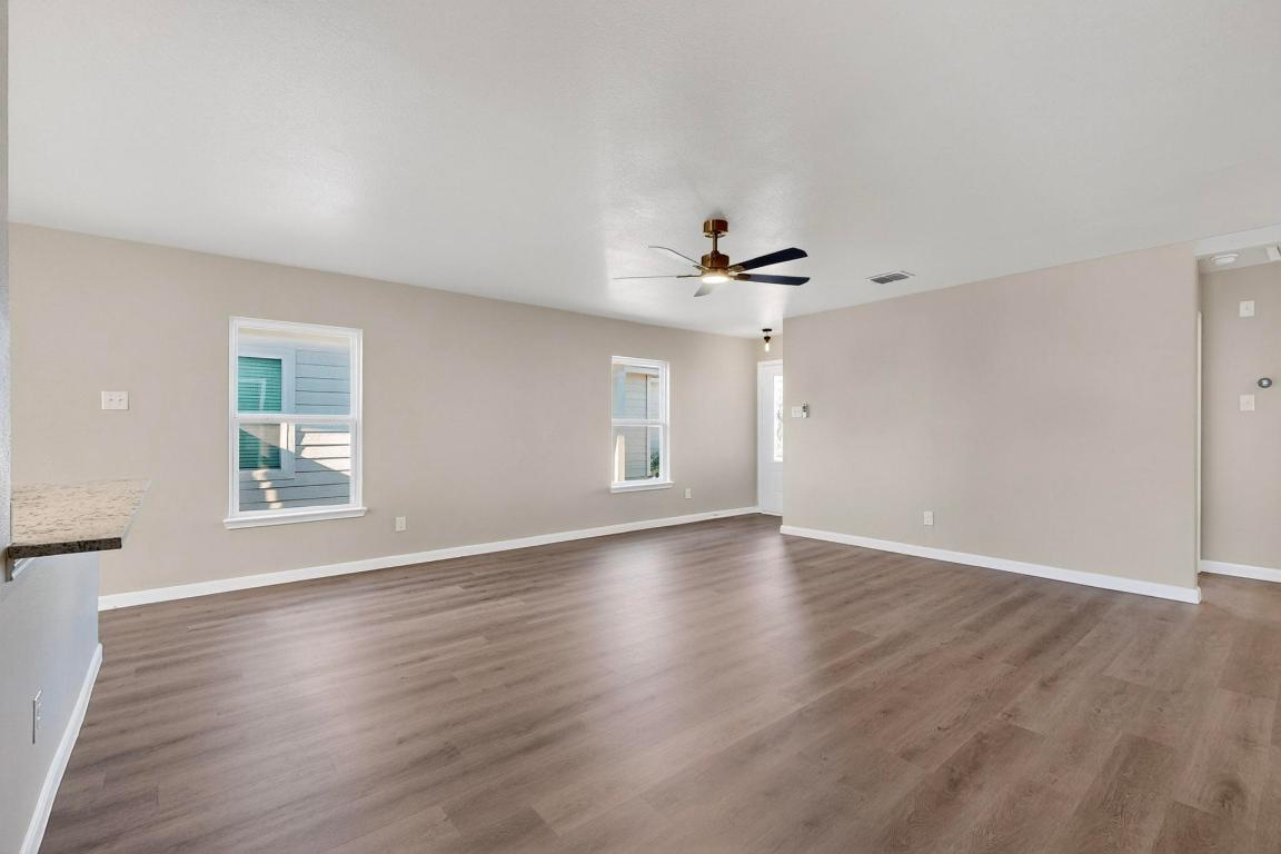 606 Aplite Pass Maxwell, TX 78656 - Photo 5 of 30 Unfurnished living room featuring dark wood-style flooring and a ceiling fan