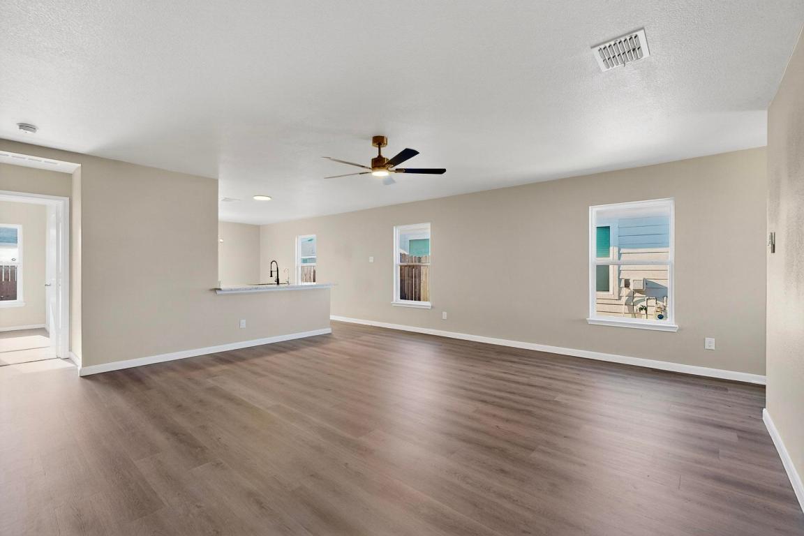 606 Aplite Pass Maxwell, TX 78656 - Photo 6 of 30 Unfurnished living room featuring dark wood-style floors, ceiling fan, and a textured ceiling