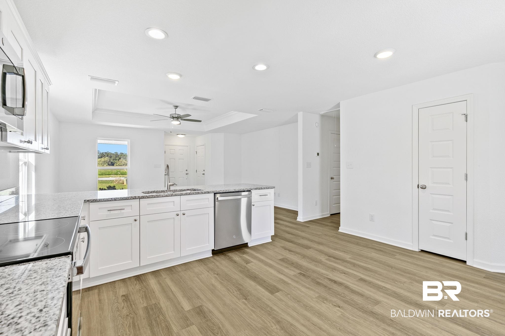 16014 Alabama Avenue Silverhill, AL 36576 - Photo 17 of 50 Kitchen with stainless steel appliances, sink, light wood-type flooring, and white cabinetry