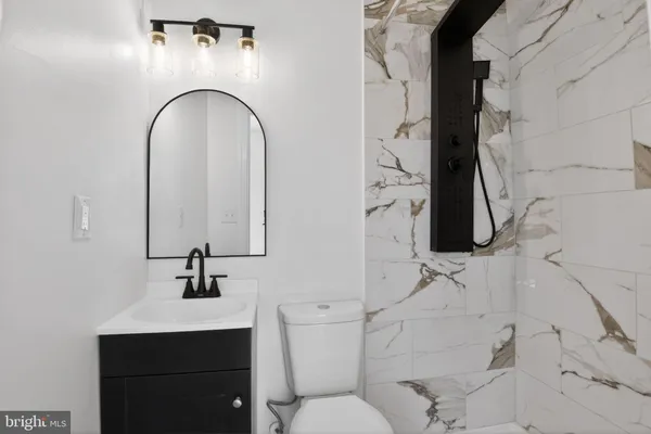a bathroom with a sink toilet and mirror
