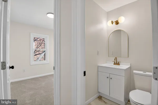 a bathroom with a toilet sink and mirror