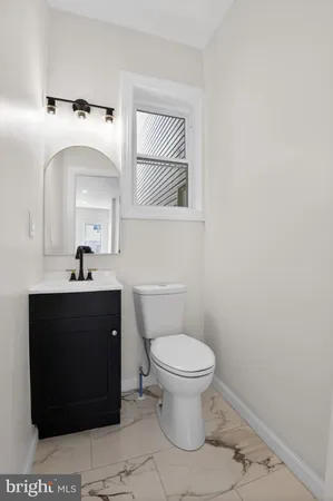 a bathroom with a toilet a sink and mirror