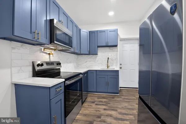 a kitchen with stainless steel appliances granite countertop wooden cabinets a stove top oven a sink and dishwasher