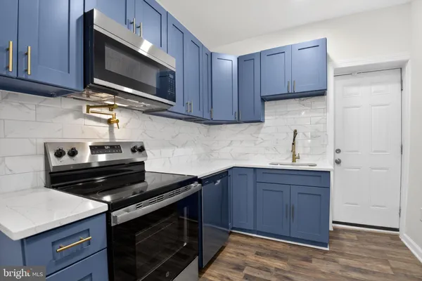 a kitchen with a sink stove and microwave