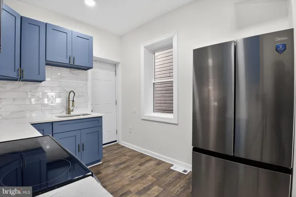 a kitchen with stainless steel appliances granite countertop a refrigerator and a sink
