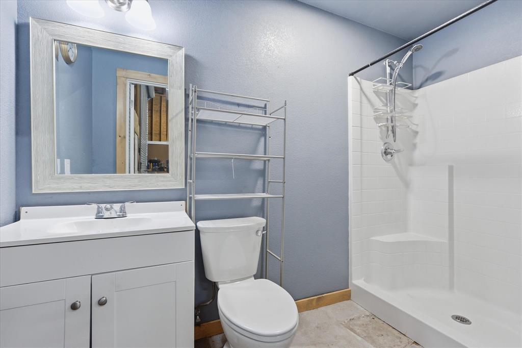 110 Highview Road Ennis, TX 75119 - Photo 28 of 40 Bathroom featuring a white vanity with integrated sink, framed mirror, and a walk-in shower with white subway tile-patterned walls and a corner seat