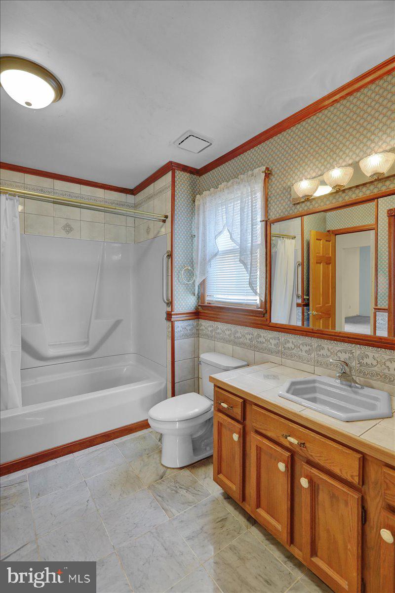 4496 Pheasant Run Reading, PA 19606 - Photo 22 of 37 a spacious bathroom with a granite countertop sink a toilet a mirror and bathtub