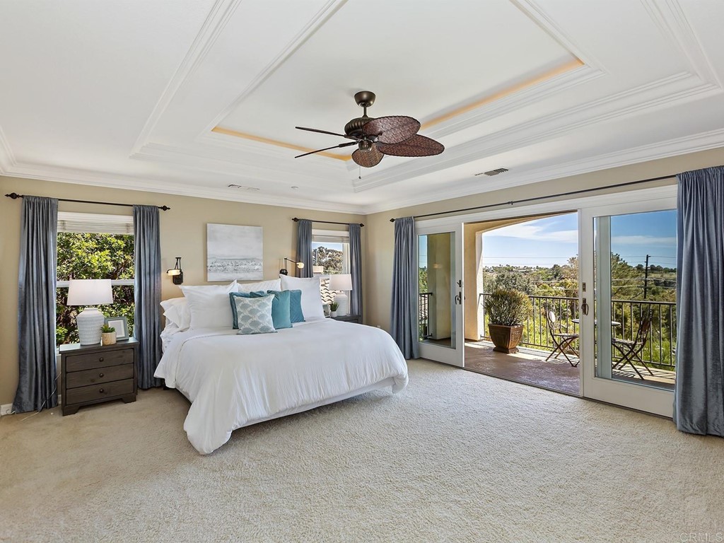 602 West Bluff Court Encinitas, CA 92024 - Photo 35 of 69 a spacious bedroom with a large bed and a chandelier fan