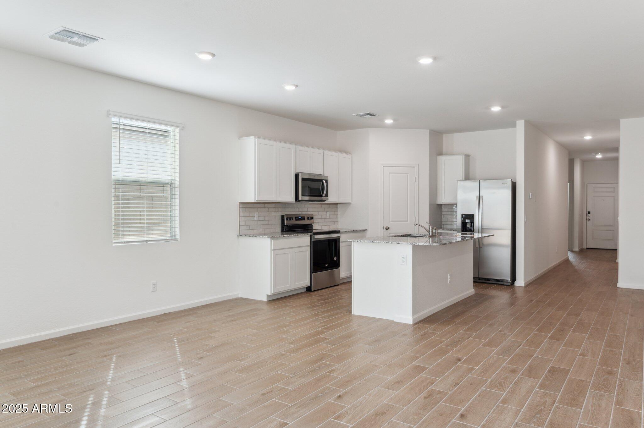25464 West Fraktur Road Buckeye, AZ 85326 - Photo 4 of 19 a kitchen with a refrigerator and a stove top oven