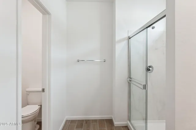a bathroom with a granite countertop shower and a toilet