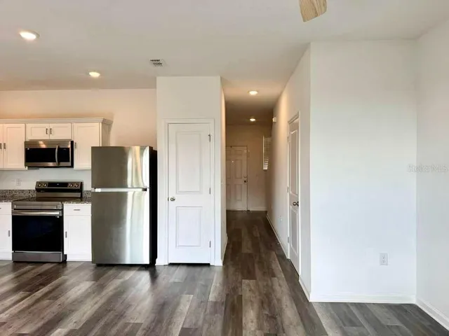 a view of a kitchen with a refrigerator and a stove top oven