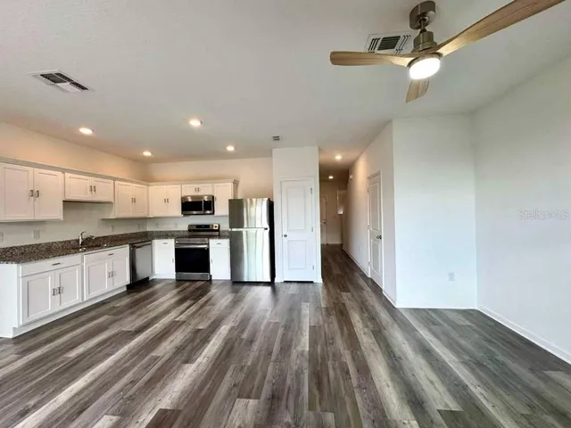 a large kitchen with a lot of counter space and stainless steel appliances