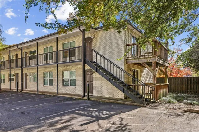a view of a large white house with large windows and a small yard