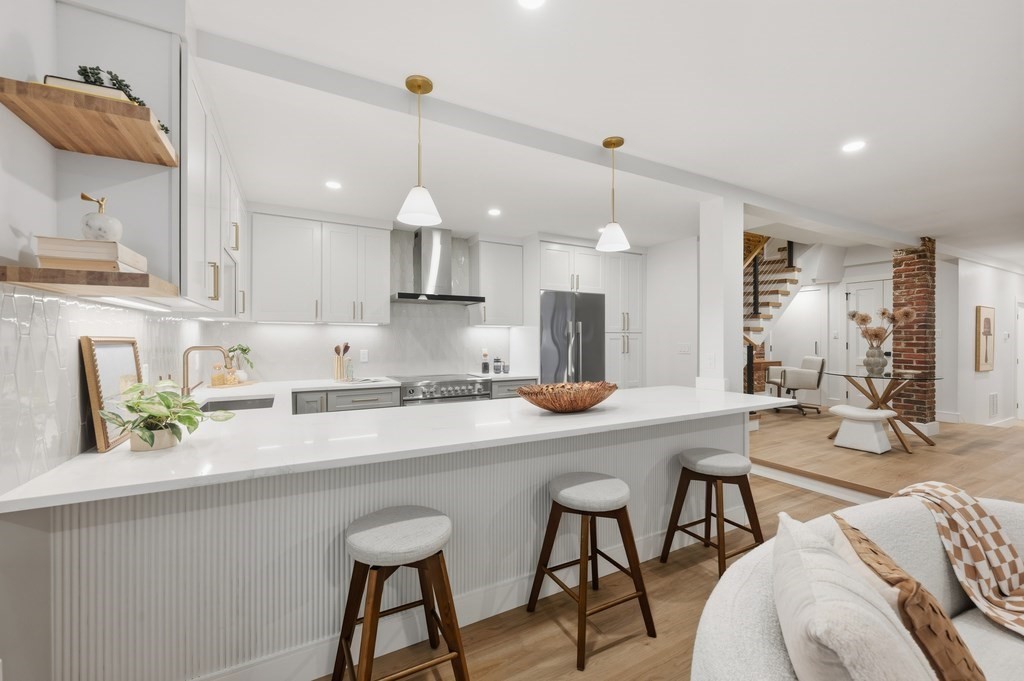 94 St Botolph Street, Unit 1 Boston, MA 02116 - Photo 12 of 37 a kitchen with stainless steel appliances a table chairs refrigerator and microwave