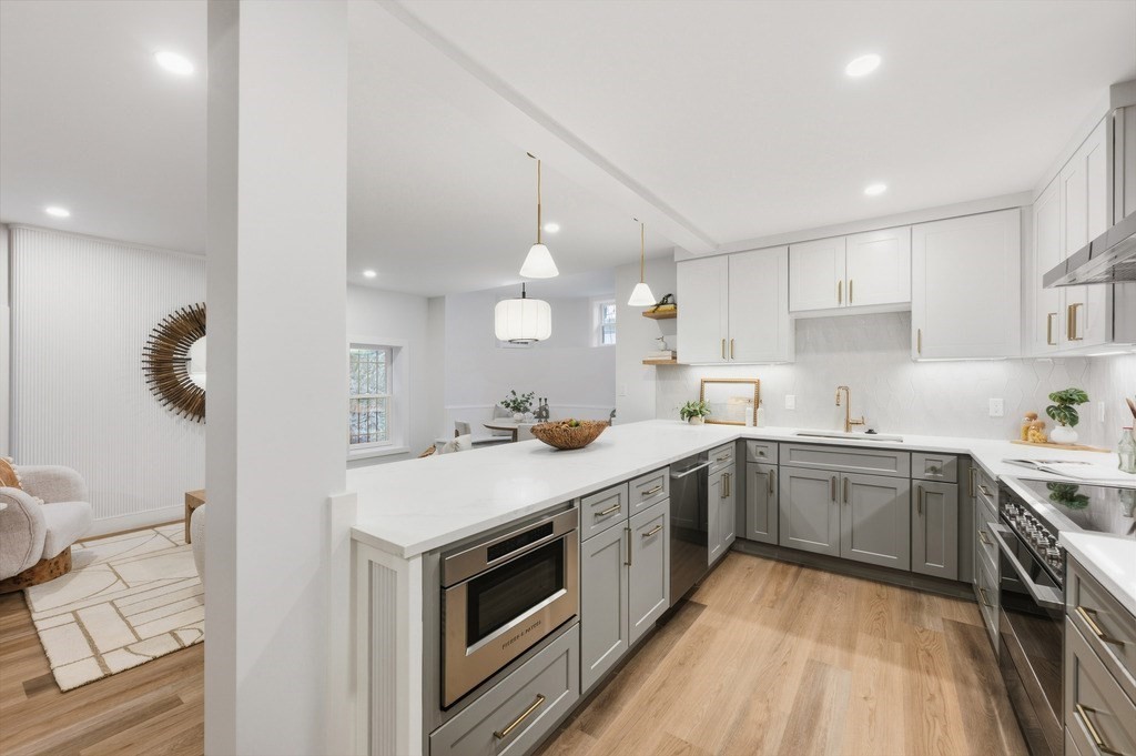 94 St Botolph Street, Unit 1 Boston, MA 02116 - Photo 6 of 37 a kitchen with a sink dishwasher a stove and white cabinets with wooden floor