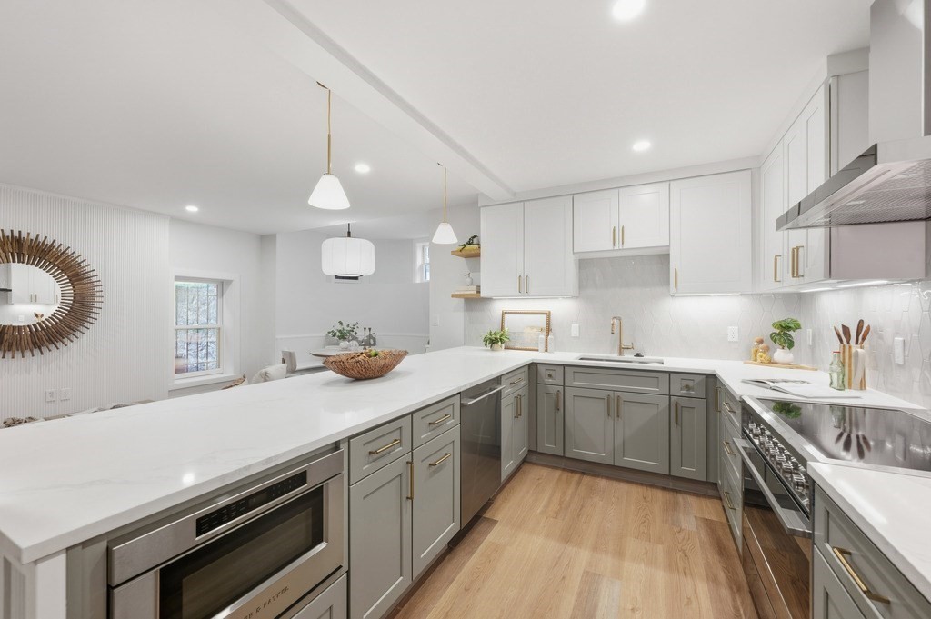 94 St Botolph Street, Unit 1 Boston, MA 02116 - Photo 10 of 37 a kitchen with a sink dishwasher a stove a dining table and chairs with wooden floor