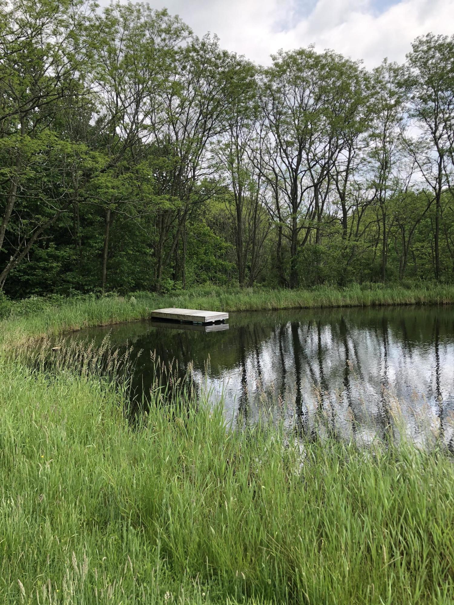 571 Spring Hill Road Moscow, PA 18444 - Photo 6 of 29 a view of a lake with a yard and large trees