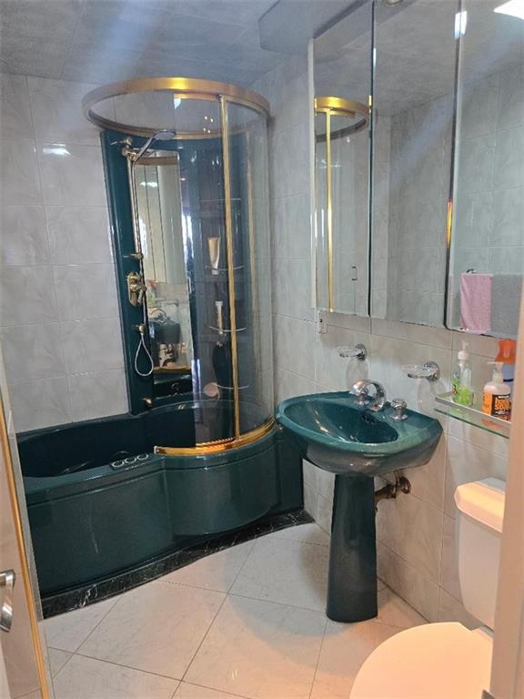 1625 Emmons Avenue, Unit 5D Brooklyn, NY 11235 - Photo 10 of 23 a bathroom with a sink a toilet and mirror