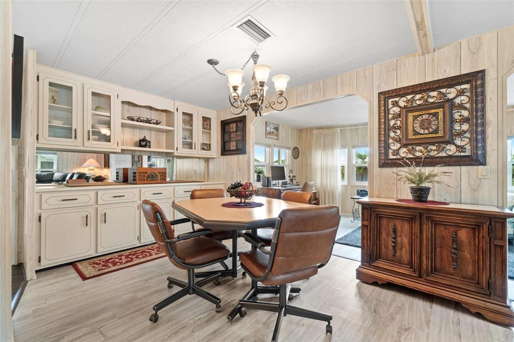 12501 Ulmerton Road, Unit 110 Largo, FL 33774 - Photo 12 of 29 a view of a dining room with furniture a chandelier and wooden floor