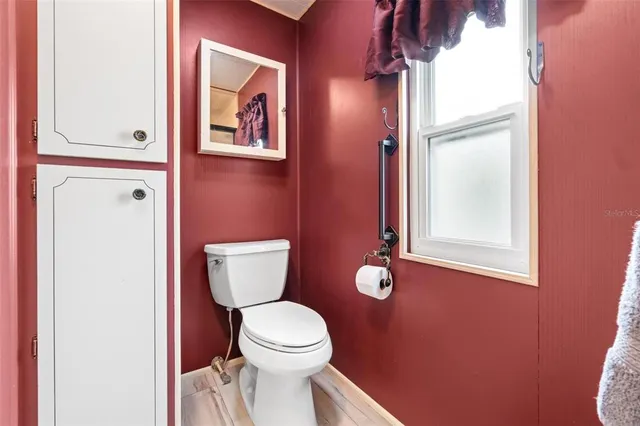 a bathroom with a toilet and a mirror