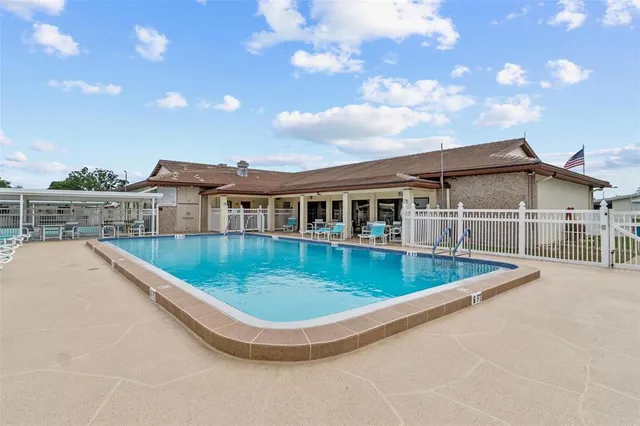a view of a house with pool and chairs