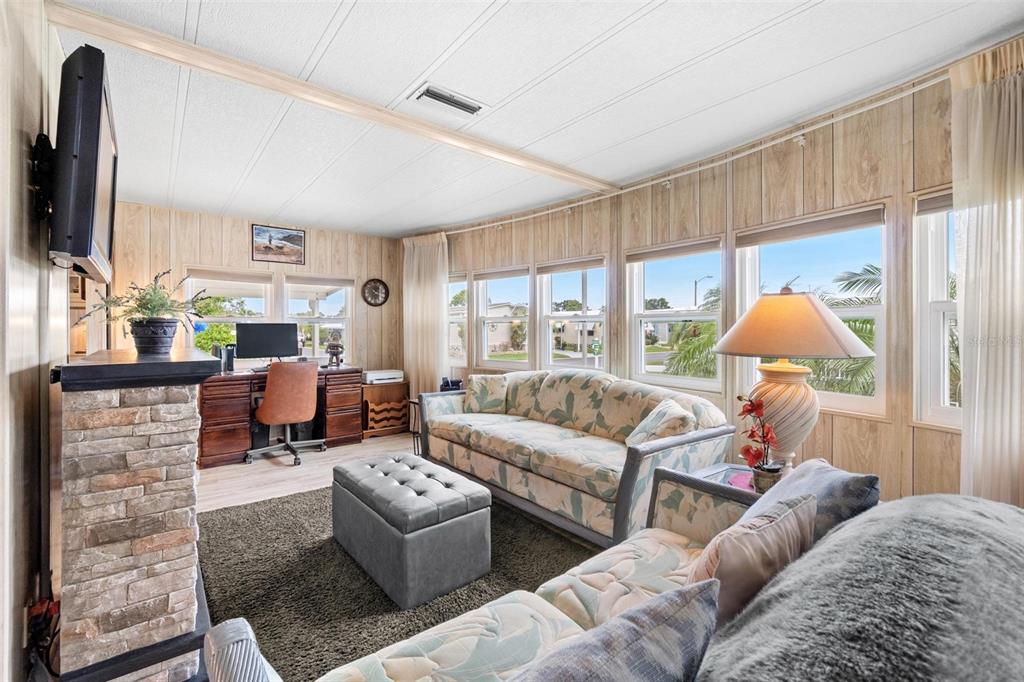 12501 Ulmerton Road, Unit 110 Largo, FL 33774 - Photo 5 of 29 a living room with fireplace furniture and a flat screen tv