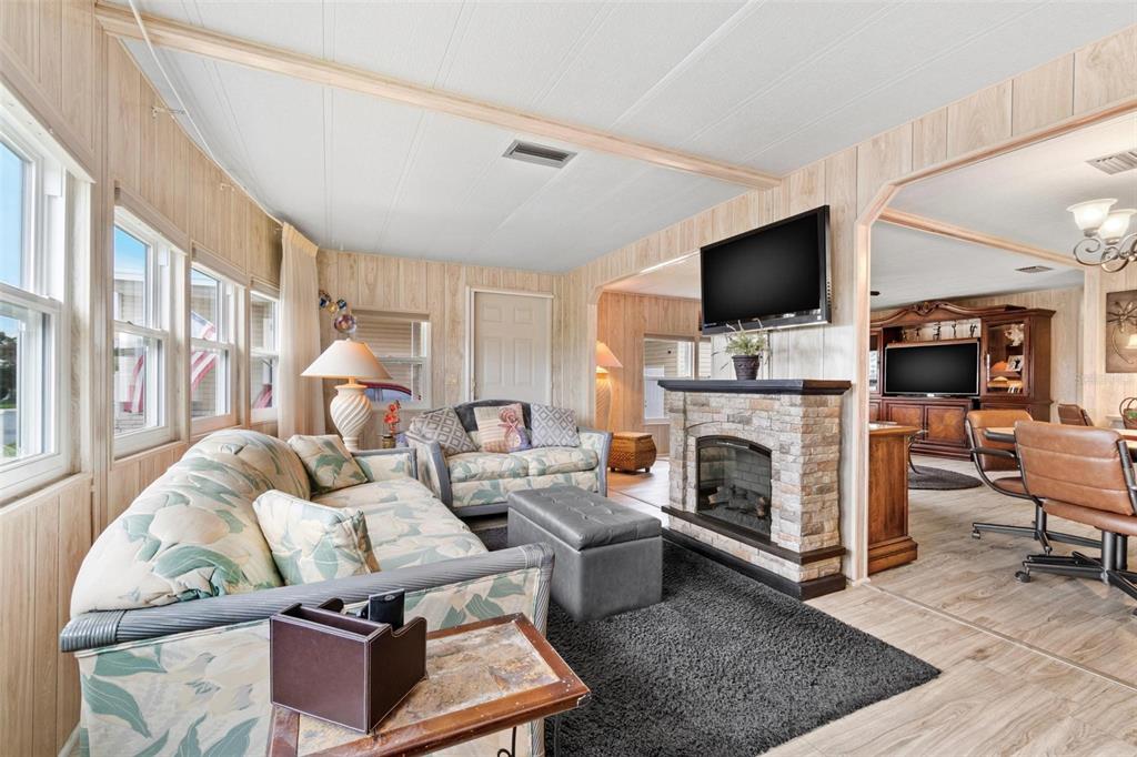 12501 Ulmerton Road, Unit 110 Largo, FL 33774 - Photo 6 of 29 a living room with furniture a flat screen tv and a fireplace