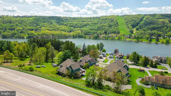 an aerial view of a house with a yard and lake view