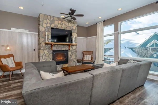 a living room with furniture a flat screen tv and a fireplace