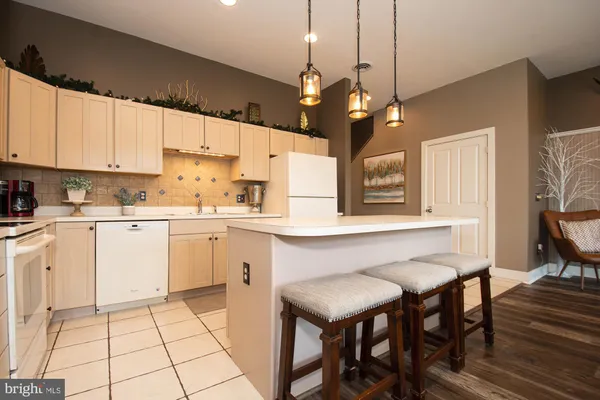 a kitchen with a table chairs and white appliances