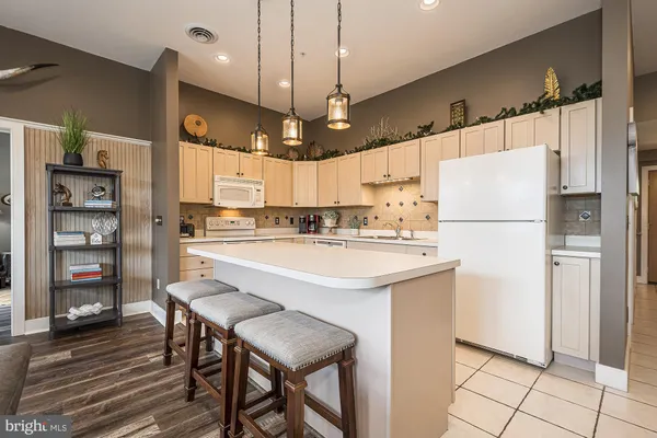a kitchen with stainless steel appliances granite countertop a refrigerator a sink and a stove