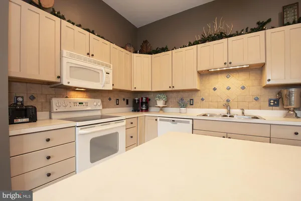 a kitchen with granite countertop white cabinets and white appliances
