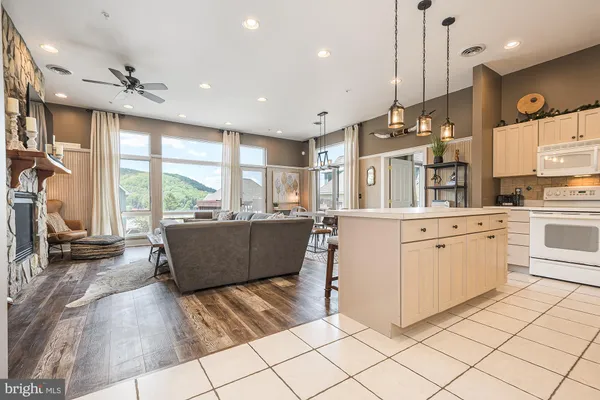 a large kitchen with kitchen island a large counter top space appliances and a ceiling fan