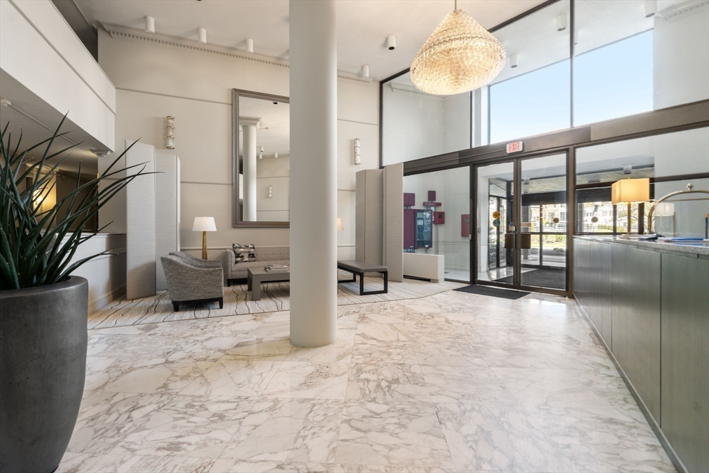 280 Boylston Street, Unit 905 Newton, MA 02467 - Photo 20 of 22 a view of a hallway with dining area and chandelier