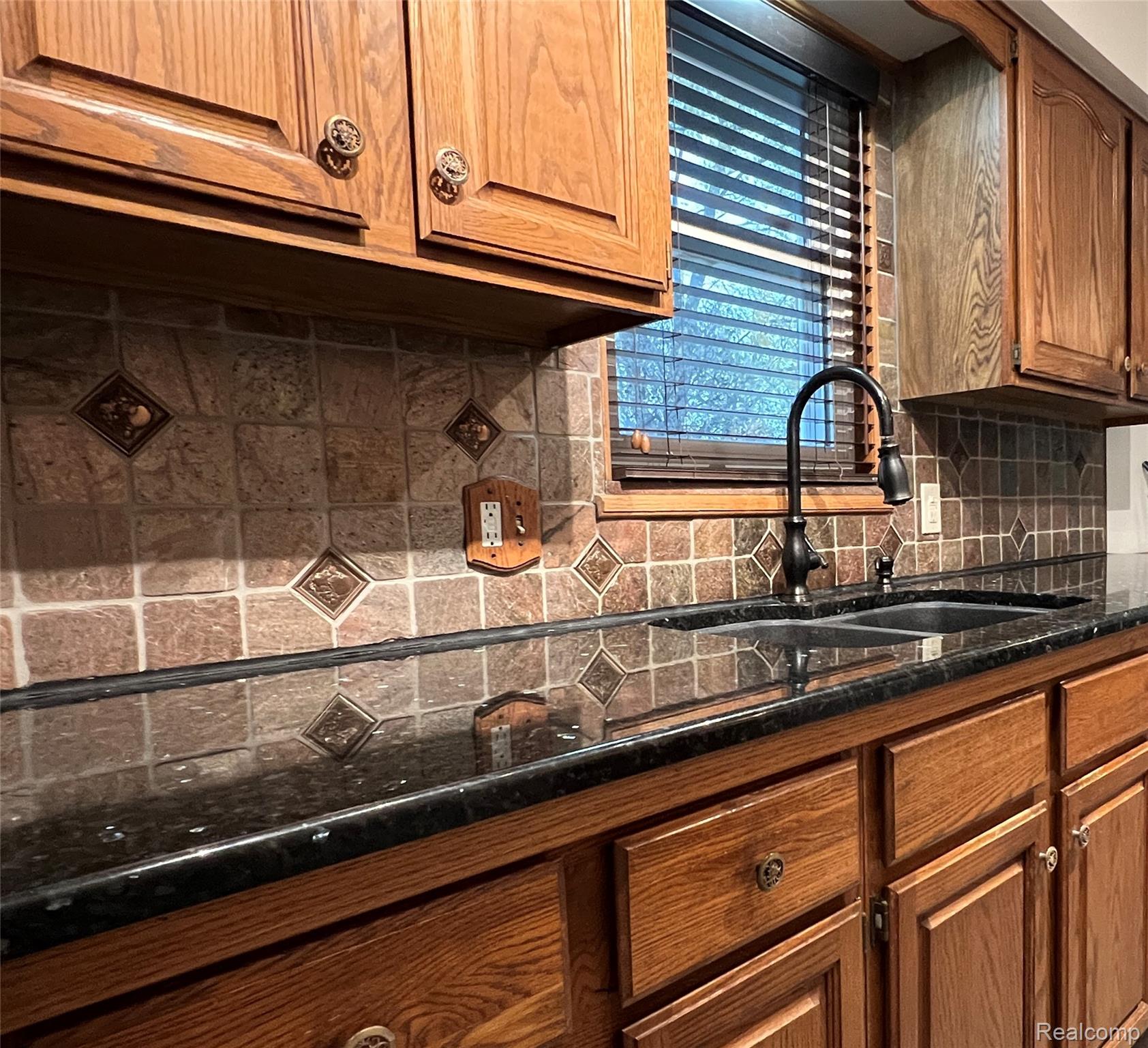 36795 Greenbush Road Wayne, MI 48184 - Photo 4 of 61 Kitchen featuring tasteful backsplash, brown cabinets, and dark stone countertops