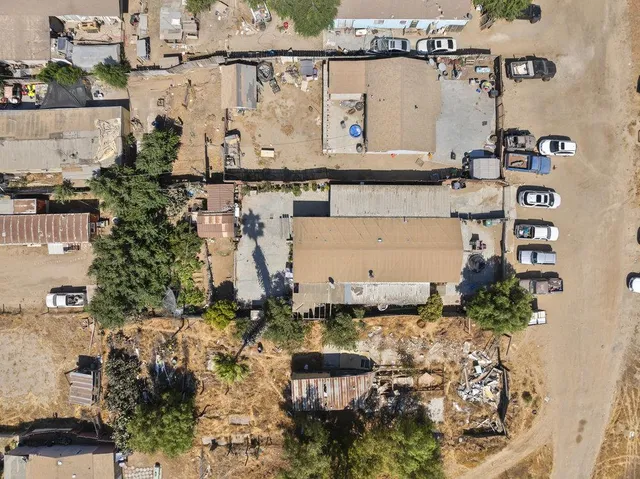 an aerial view of a house with a yard and large tree