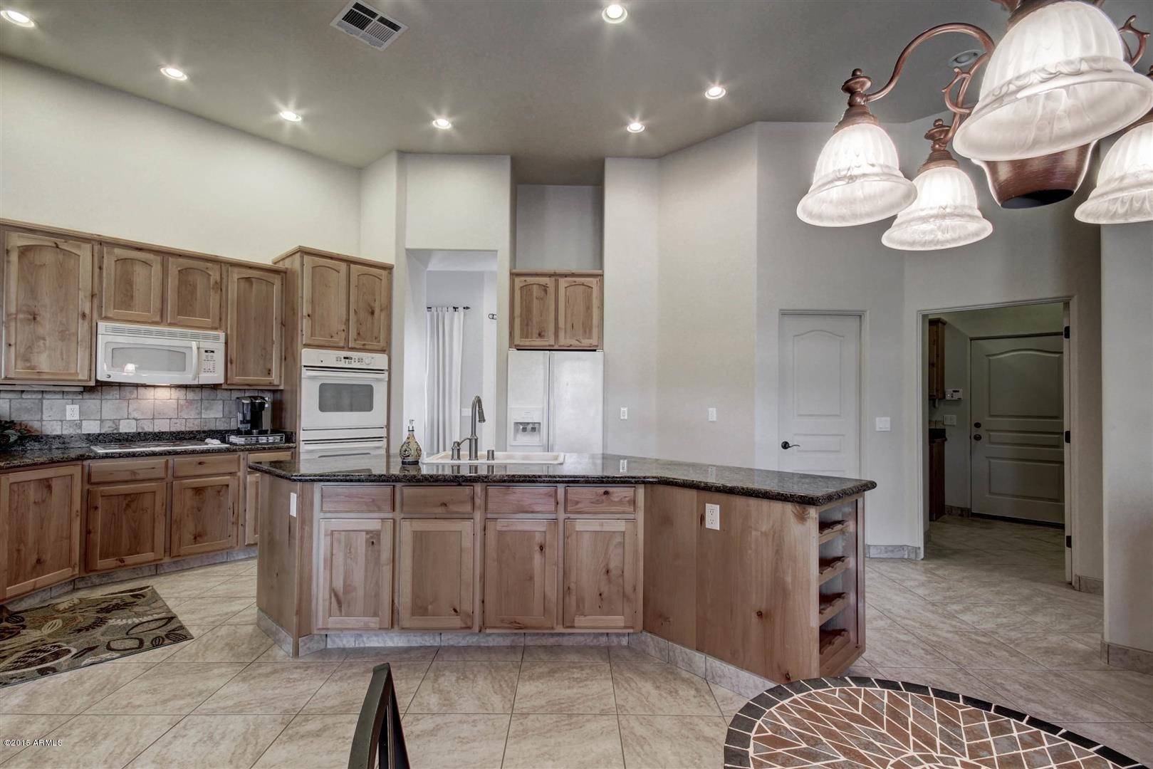 4932 North Wolverine Pass Road Apache Junction, AZ 85119 - Photo 38 of 66 a kitchen with stainless steel appliances granite countertop a sink and cabinets