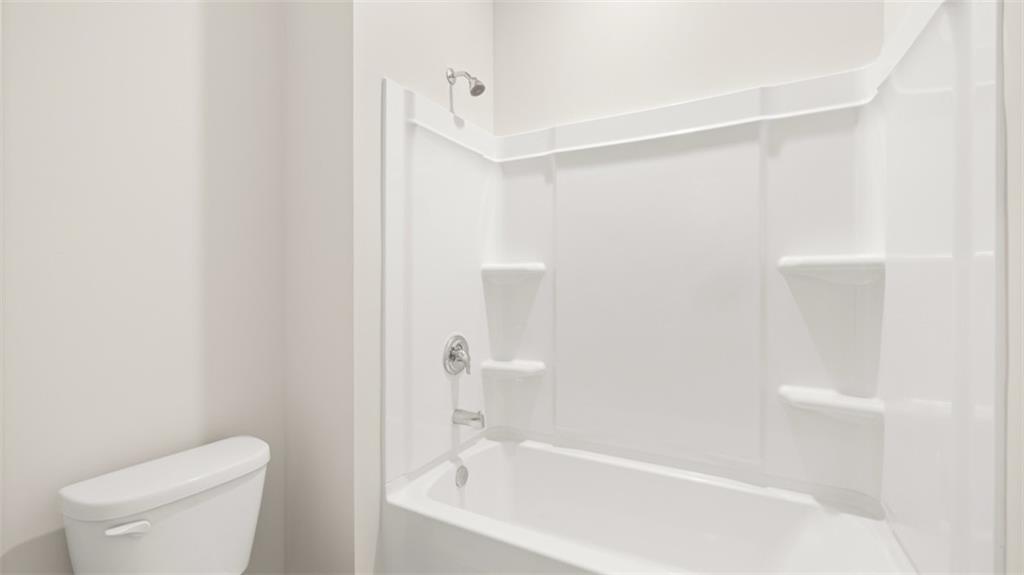 2242 Edgecombe Lane Dacula, GA 30019 - Photo 33 of 33 a bathroom with a bathtub and a toilet
