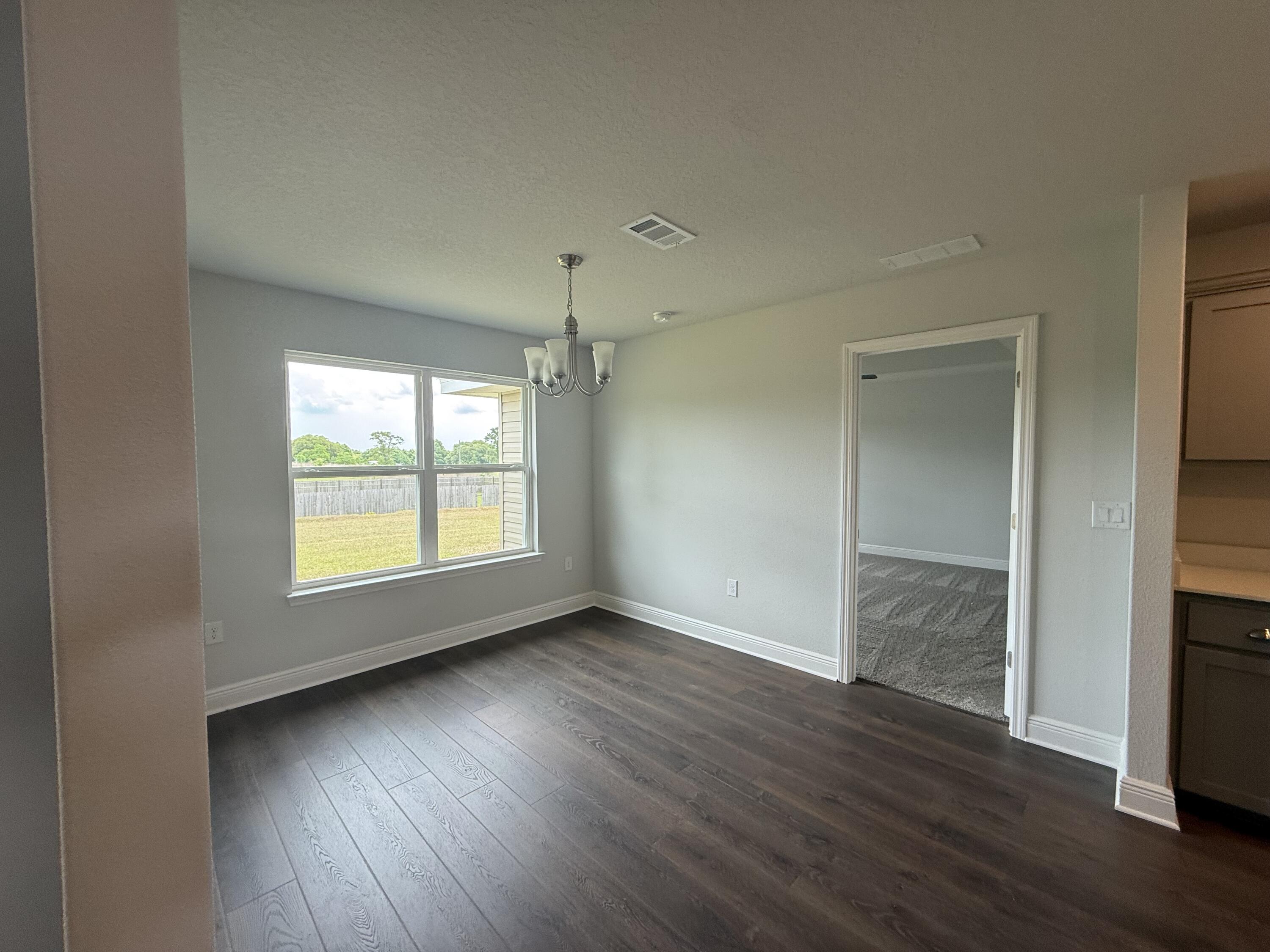 6004 Crocket Cove Crestview, FL 32539 - Photo 19 of 24 a view of an empty room with wooden floor and a window