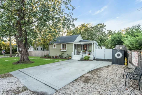 a view of a house with a yard and large trees