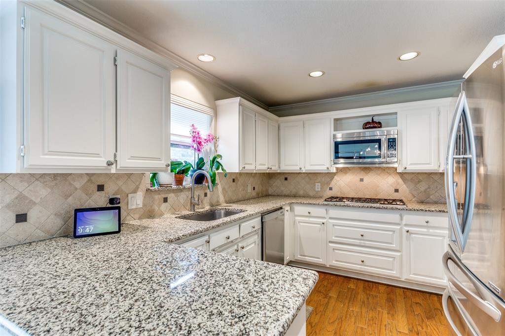 2229 Weatherbee Street Fort Worth, TX 76110 - Photo 20 of 25 Kitchen with light wood-type flooring, white cabinetry, light stone counters, a sink, and stainless steel appliances