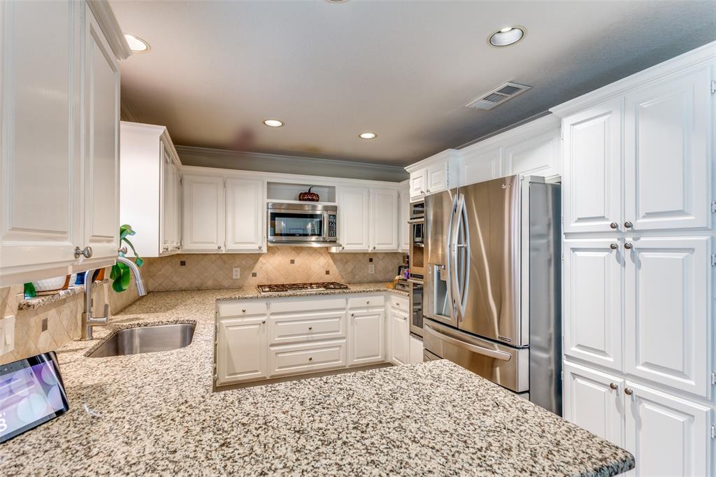 2229 Weatherbee Street Fort Worth, TX 76110 - Photo 9 of 25 Kitchen featuring decorative backsplash, visible vents, a sink, white cabinets, and stainless steel appliances